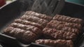 Flipping Cevapcici Sausages on Grill Pan. Royalty Free Stock Photo