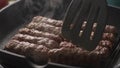 Flipping Cevapcici Sausages on Grill Pan. Royalty Free Stock Photo