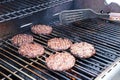 Flipping hamburgers on a BBQ grill outside