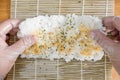 Flipping seasoned short grain rice on a Makisu. Making sushi rolls Royalty Free Stock Photo