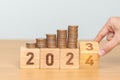 flipping 2023 to 2024 year block with Coins stack. Money, Budget, tax, investment, financial, savings and New Year Resolution