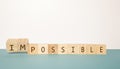 Flipping two wooden cube to change the word Impossible to Possible on neutral background Royalty Free Stock Photo