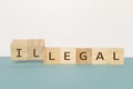 Flipping two wooden cube to change the word Legal to Illegal on neutral background
