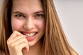 flirtatious girl with natural long brown hair looking at camera and smiling, close-up