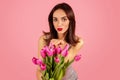 Flirtatious woman with red lipstick, sending a kiss over a bouquet of fresh pink tulips Royalty Free Stock Photo