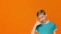 Flirty boy making call me gesture, orange background Royalty Free Stock Photo