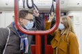 Flirty couple with covid 19 face masks in a train Royalty Free Stock Photo