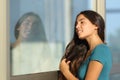 Flirty teen girl combing her hair using a window like a mirror Royalty Free Stock Photo