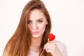 Flirty woman holding red wooden heart on stick