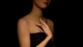 Flirty woman stroking her body on dark background, prostitution concept