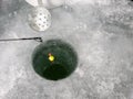 A float sits in a an ice fishing hole.