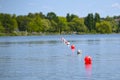 Floating balls in red and white mark the finish line on the lake during a rowing regatta, copy space, selected focus