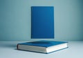 Floating blue book above a closed blue book on a minimalist background Royalty Free Stock Photo
