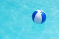 Floating blue and white beachball in swimming pool. Royalty Free Stock Photo