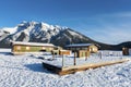 Floating Boat Dock Platform on a Frozen Snow Covered Lake with Banff Mountain Peak on Skyline