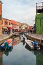 Floating boats on the canal between small colored houses