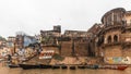 Floating boats and diversity of Indian people living at the ghat with old buildings on background along the Ganges Ganga river.