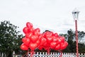 A floating bouquet of red, heart-shaped balloons