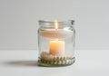 A floating candle in a glass jar, on a solid white background Royalty Free Stock Photo