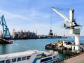 Floating cargo crane with a ladle in the seaport over the sea and Granary elevators, Tugboat assist, boats and cranes. Industrial Royalty Free Stock Photo