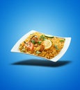 Floating Chicken Biryani on white plate on blue gradient