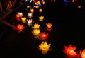 Floating colored lanterns and garlands on river at night on Vesak day for celebrating Buddha's birthday in Eastern culture, that