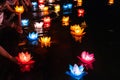 Floating colored lanterns and garlands on river at night on Vesak day for celebrating Buddha's birthday in Eastern culture, that