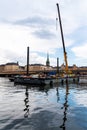 Floating construction barge with a crane on the harbour against cityscape of Stockholm Royalty Free Stock Photo