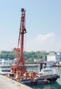 Floating crane and marine tug at the sea port berth Royalty Free Stock Photo