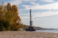 Floating crane moored to sandy river shore at autumn day Royalty Free Stock Photo