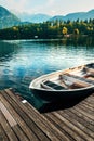 Floating dinghy moored to a wooden pier at Lake Bohinj in Slovenia Royalty Free Stock Photo