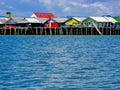 Floating fisherman village on man-made island with colorful roof and vintage houses on the blue sea with clear blue sky.