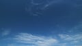 Floating fluffy cirrus clouds. Beautiful sunny blue sky with wispy smoky white.