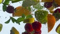 Floating fresh fruits underwater in super slow motion close up. Healthy food.