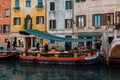 Floating fruit shop in a narrow street with colorful buildings by the canal in Venice