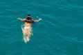 Floating girl in white swimsuits in the blue sea