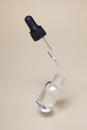 Floating glass dropper bottle with serum or oil and flying pipette