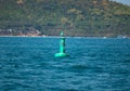 Floating green navigational buoy on blue sea. Marine signal buoy. Navigational Buoy marking a shipping channel Royalty Free Stock Photo