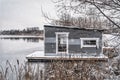 Floating grey cabin on the freezing lake