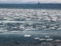 Floating ice with oil rig in the background Royalty Free Stock Photo