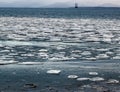 Floating ice with oil rig in the background