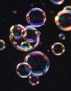 Floating iridescent soap bubbles on black background against diffused light Royalty Free Stock Photo