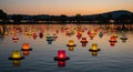 Floating lanterns decorate a tranquil body of water during dusk, with a gradient sky in Royalty Free Stock Photo