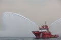 A floating modern tug boat sprays jets