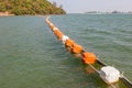 Floating orange and white buoys for marking safety zone. Royalty Free Stock Photo