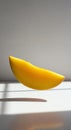 Floating peeled mango slice with sunlight backlight and soft shadow on seamless white surface Royalty Free Stock Photo