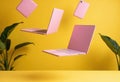 Floating pink laptops and a smartphone against a vibrant yellow background Royalty Free Stock Photo