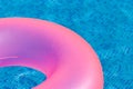 Floating pink ring on blue water swimpool. Royalty Free Stock Photo