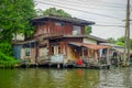 Floating poor house with cable lines at the riverside on the Chao Phraya river. Thailand, Bangkok Royalty Free Stock Photo