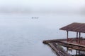 Floating raft house on river with foggy and long tail boat on background. Royalty Free Stock Photo